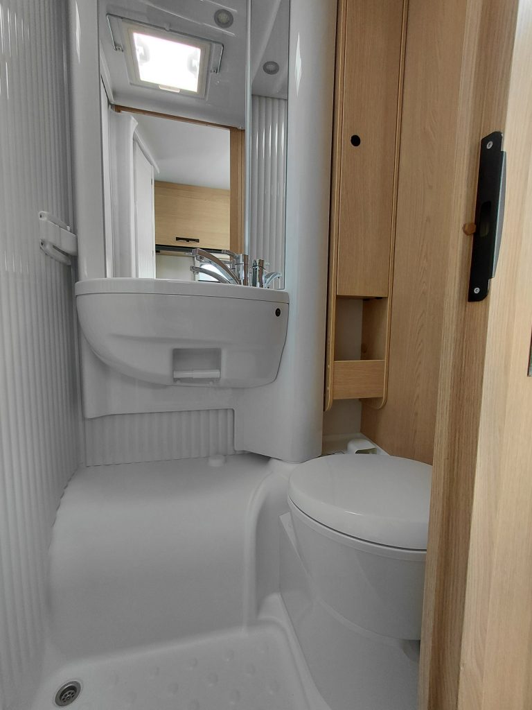Kompaktes Bad im Wohnmobil mit Waschbecken, Spiegel und Toilette